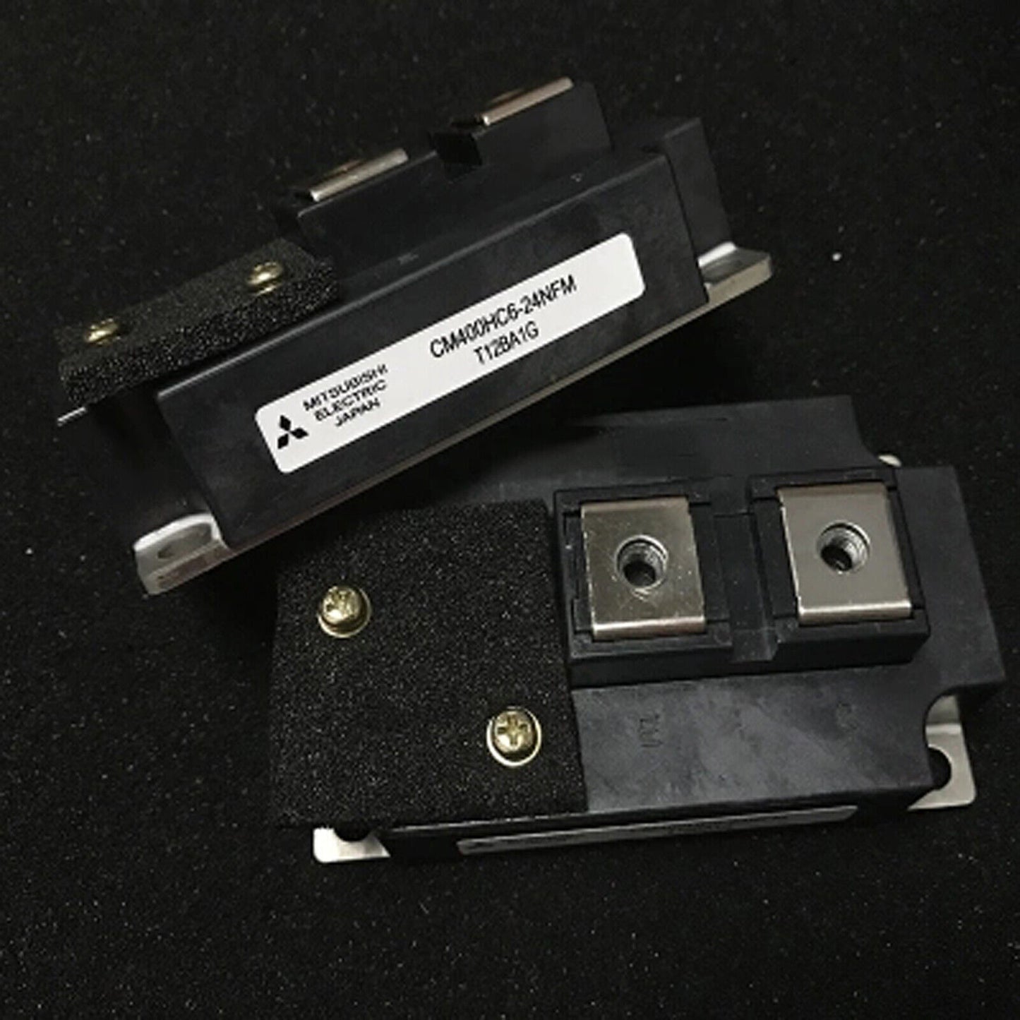 Mitsubishi CM400HC6-24NFM IGBT module, black component with metallic plates and screws, industrial automation part, Japan.