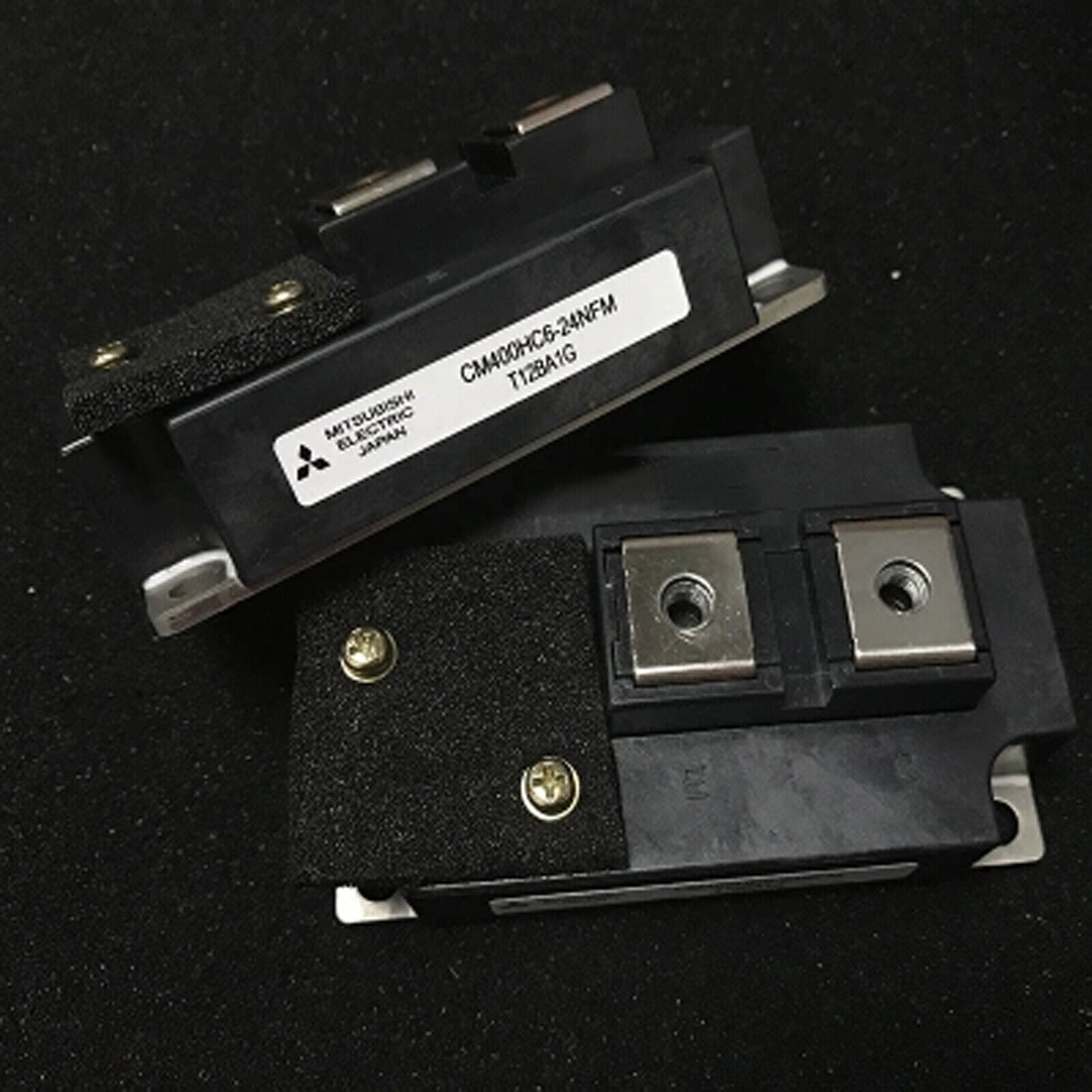 Mitsubishi CM400HC6-24NFM IGBT module, black component with metallic plates and screws, industrial automation part, Japan.