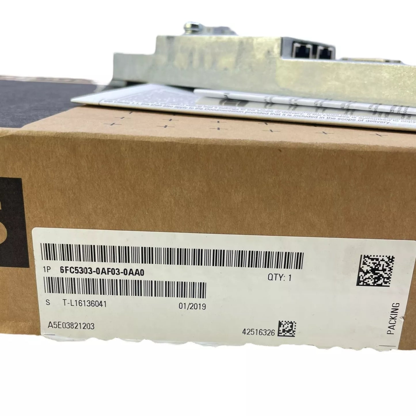 Siemens 6FC5303-0AF03-0AA0 PLC control panel in a cardboard box. Part number, quantity, and packing label visible.