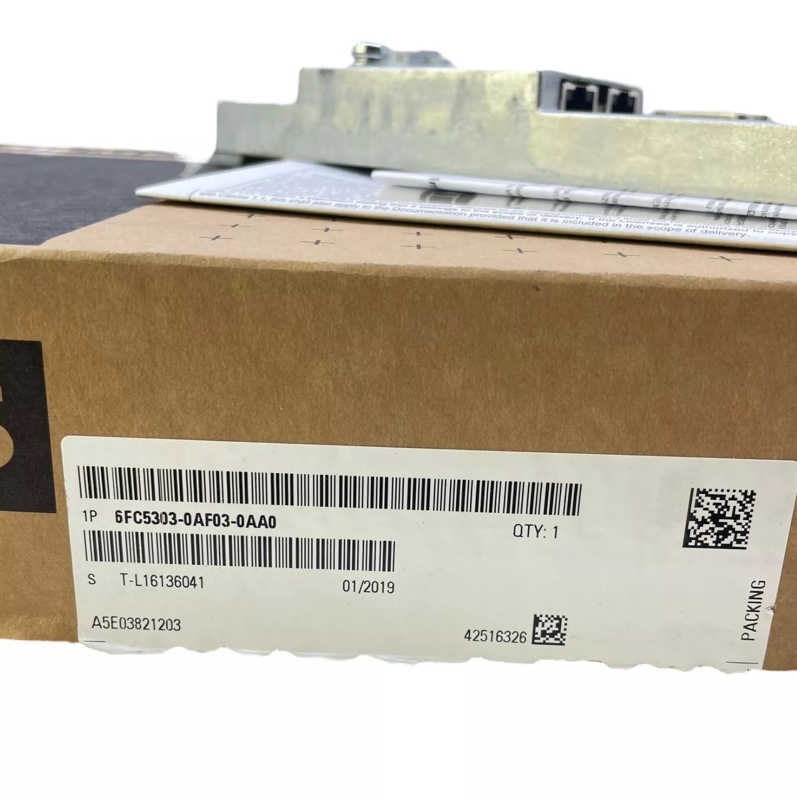 Siemens 6FC5303-0AF03-0AA0 PLC control panel in a cardboard box. Part number, quantity, and packing label visible.