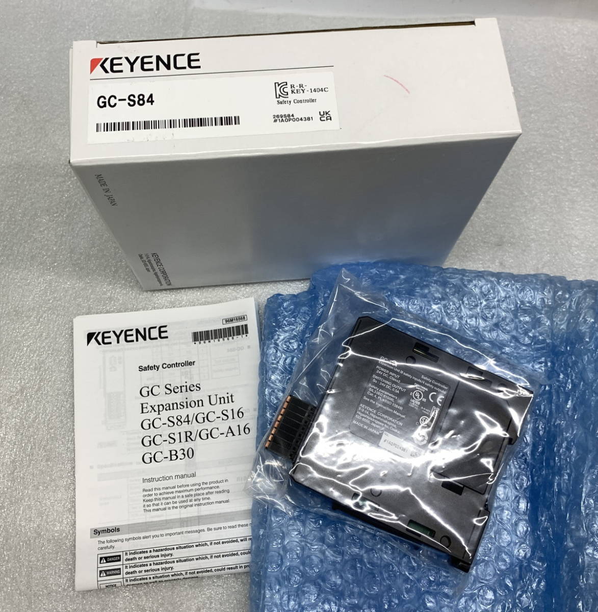 Keyence GC-S84 Safety I/O Unit in packaging, industrial automation component, with product details and manual.