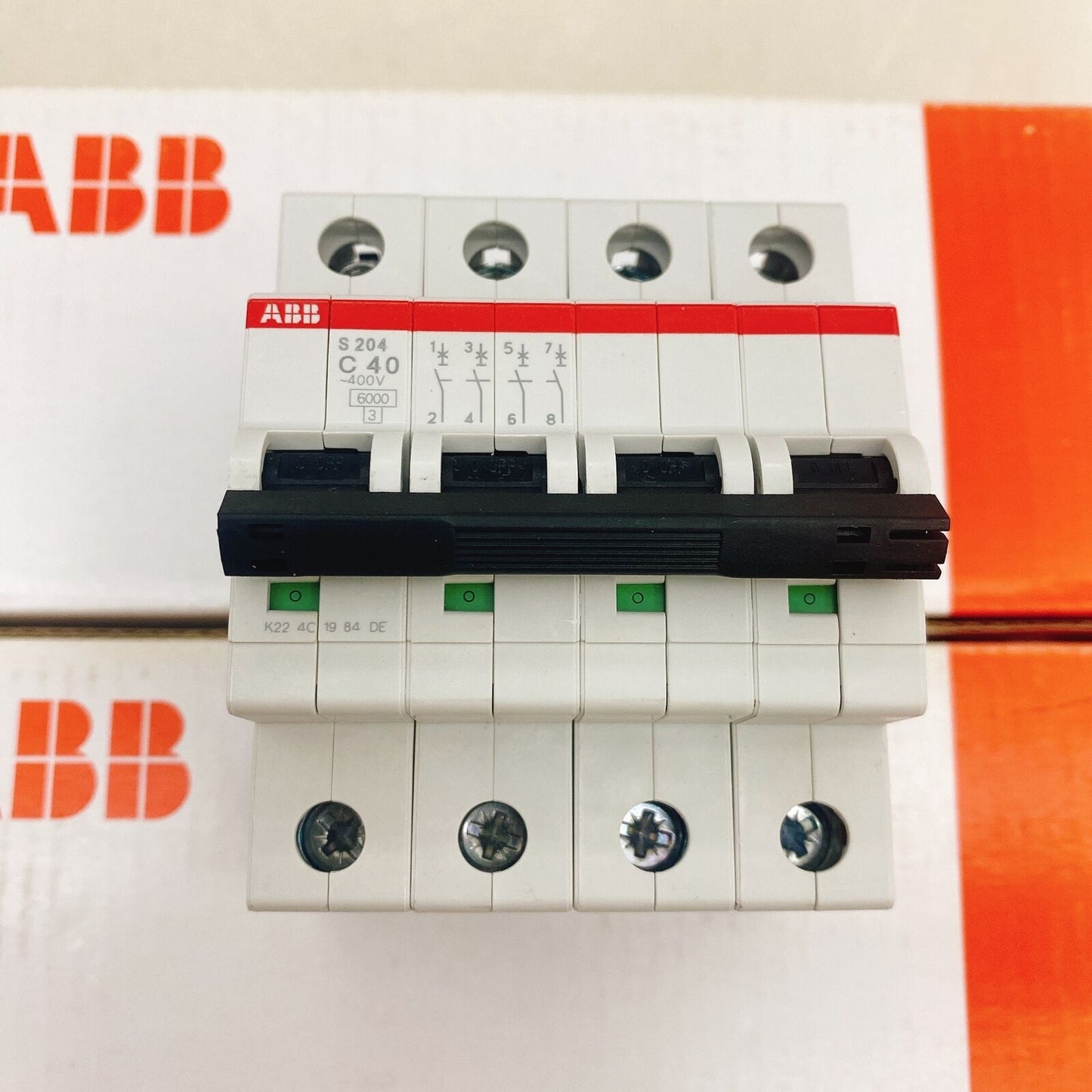 ABB S204-C40 4P circuit breaker. White body with black lever and green indicators. PLC system component.