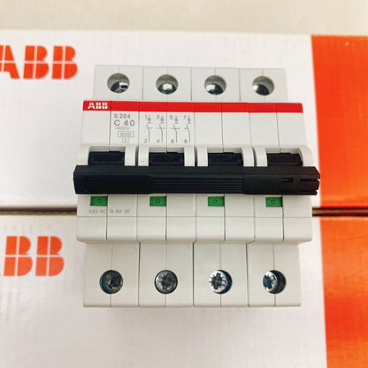 ABB S204-C40 4P circuit breaker. White body with black lever and green indicators. PLC system component.