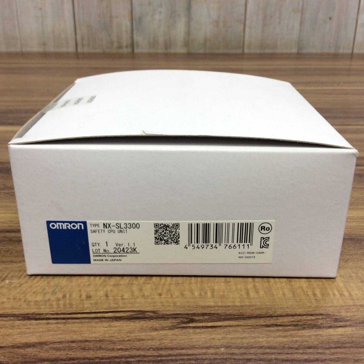 OMRON NX-SL3300 Safety CPU Unit box on a wooden surface.