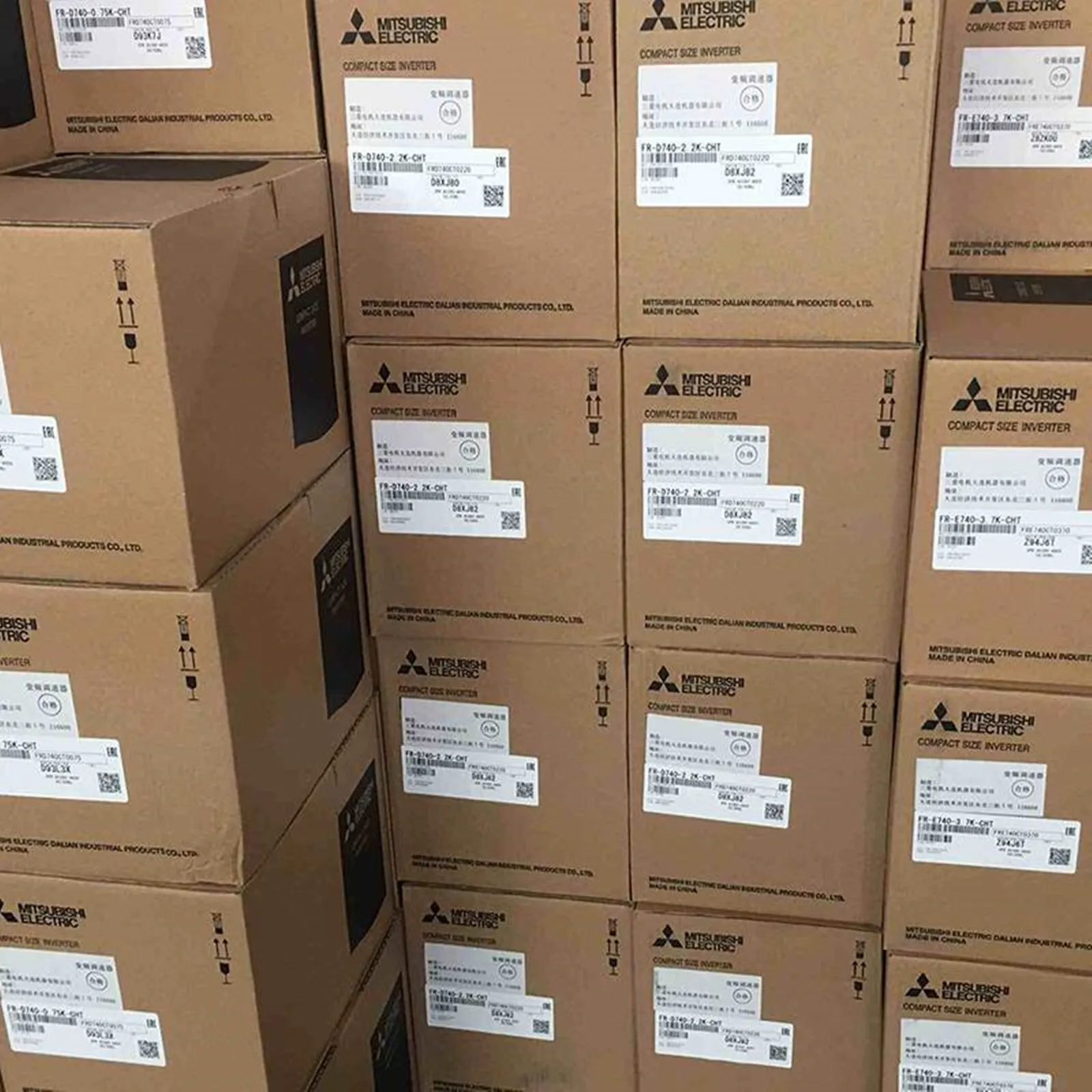 Mitsubishi Compact Size Inverter boxes stacked, new automation parts, featuring product labels and brand logo.