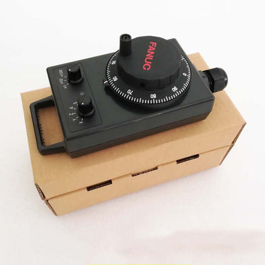 FANUC A860-0203-T014 Manual Pulse Generator on cardboard box. Black control panel, industrial automation part.