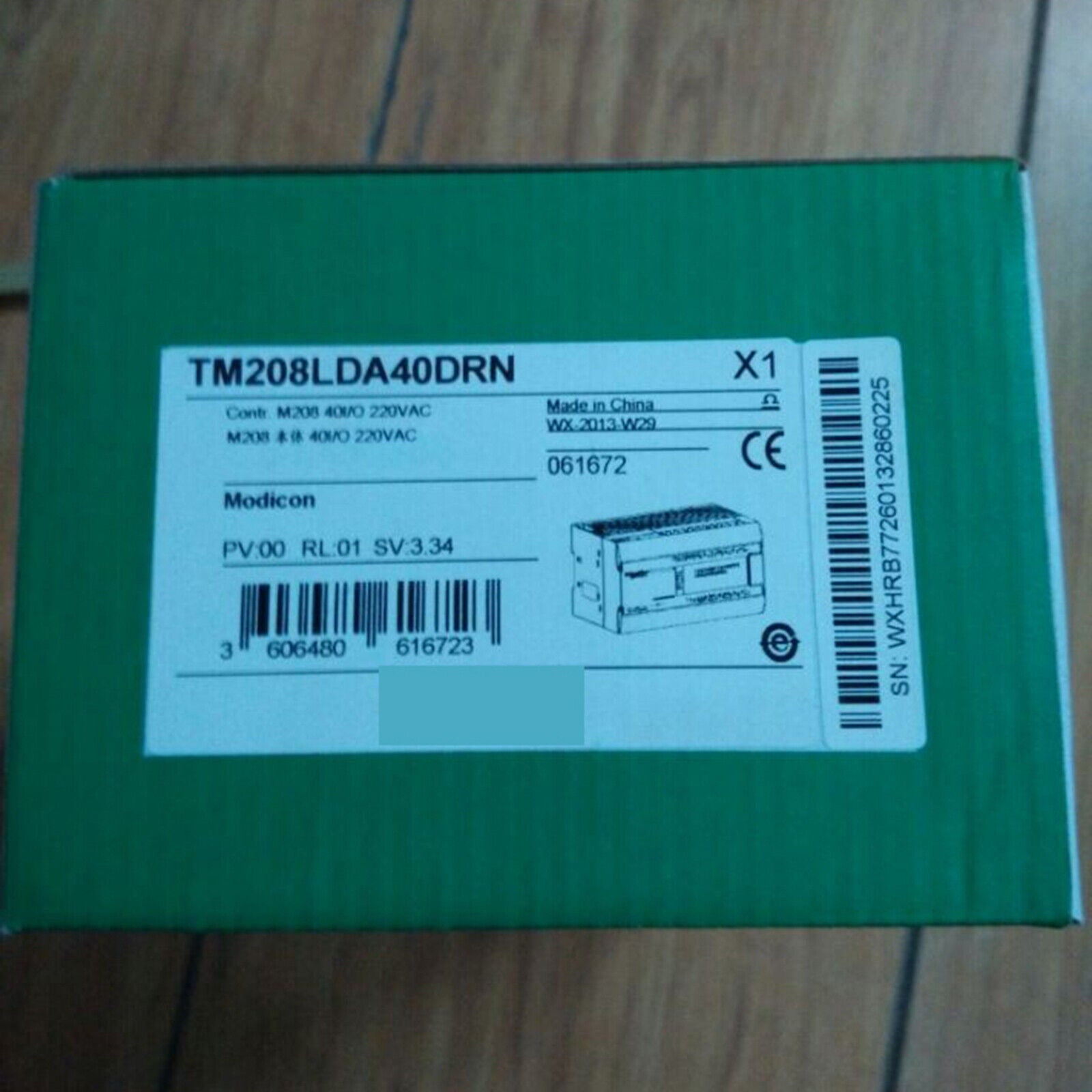 Schneider TM208LDA40DRN PLC module in green box, industrial automation part.