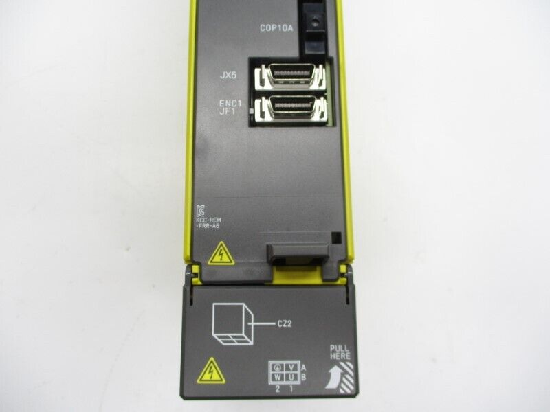 FANUC industrial automation module detail, yellow and black with ports and labels, including text 'PULL HERE'.