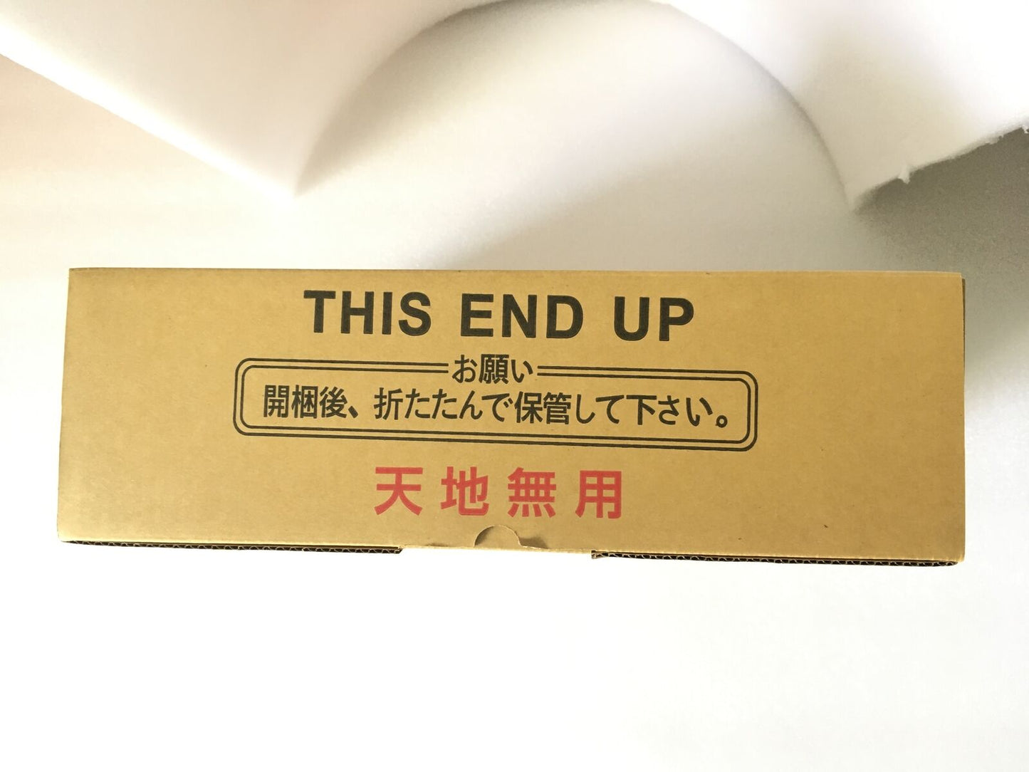Brown cardboard box labeled "THIS END UP" with Japanese text, indicating fragile contents for industrial automation parts.