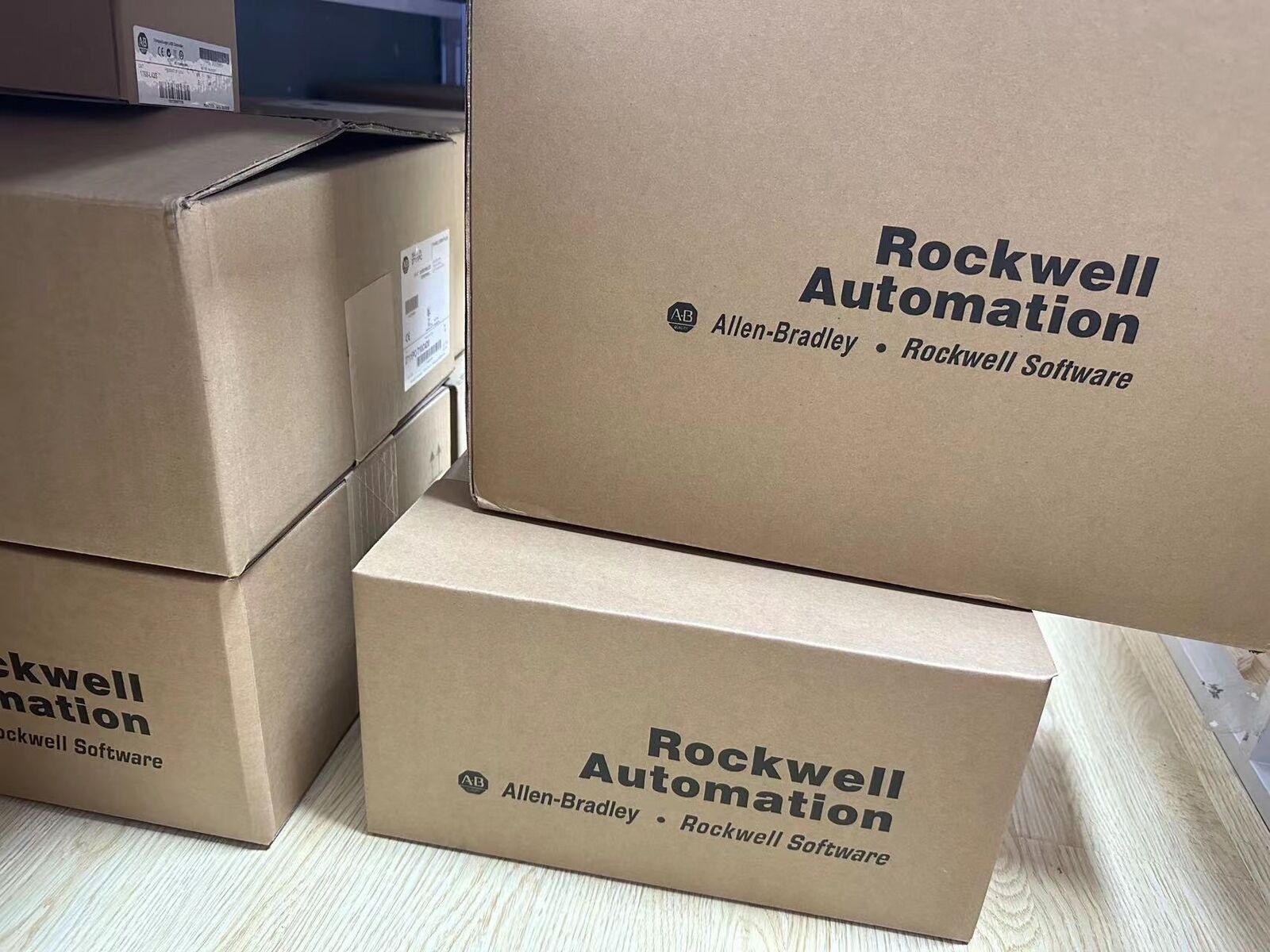 Allen-Bradley industrial automation parts in boxes, Rockwell Automation logo visible.