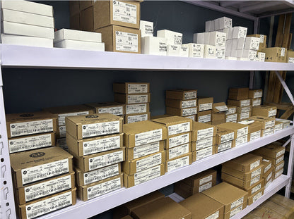 Allen-Bradley industrial automation parts in boxes on shelves. Factory sealed new automation parts ready for shipment.