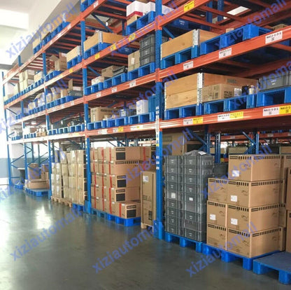 Warehouse filled with industrial automation parts, including Siemens PLC modules and other equipment, ready for shipping.